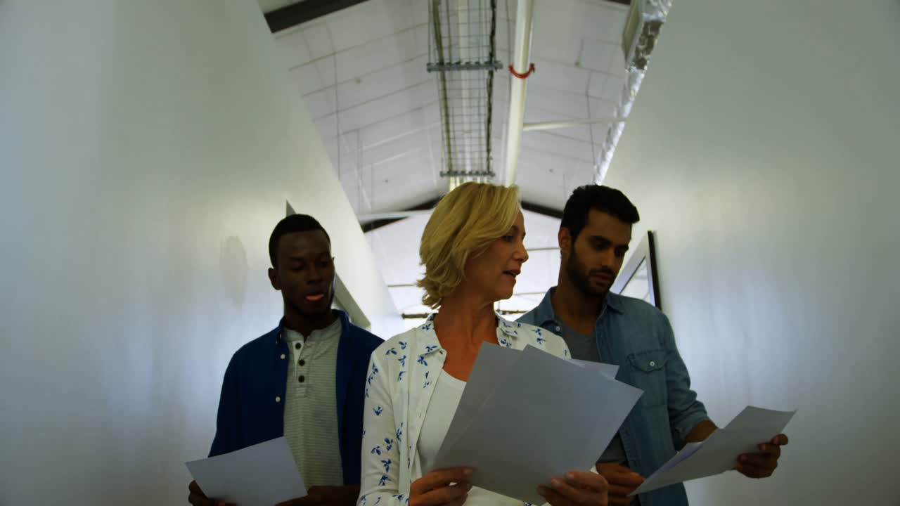 ejecutivos interactuando entre sí mientras caminan por el pasillo