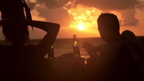 drinking beer on the beach at sunset