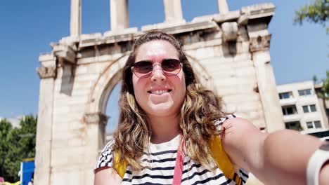 happy tourist takes a selfie at hadrian's arch in athens, greece