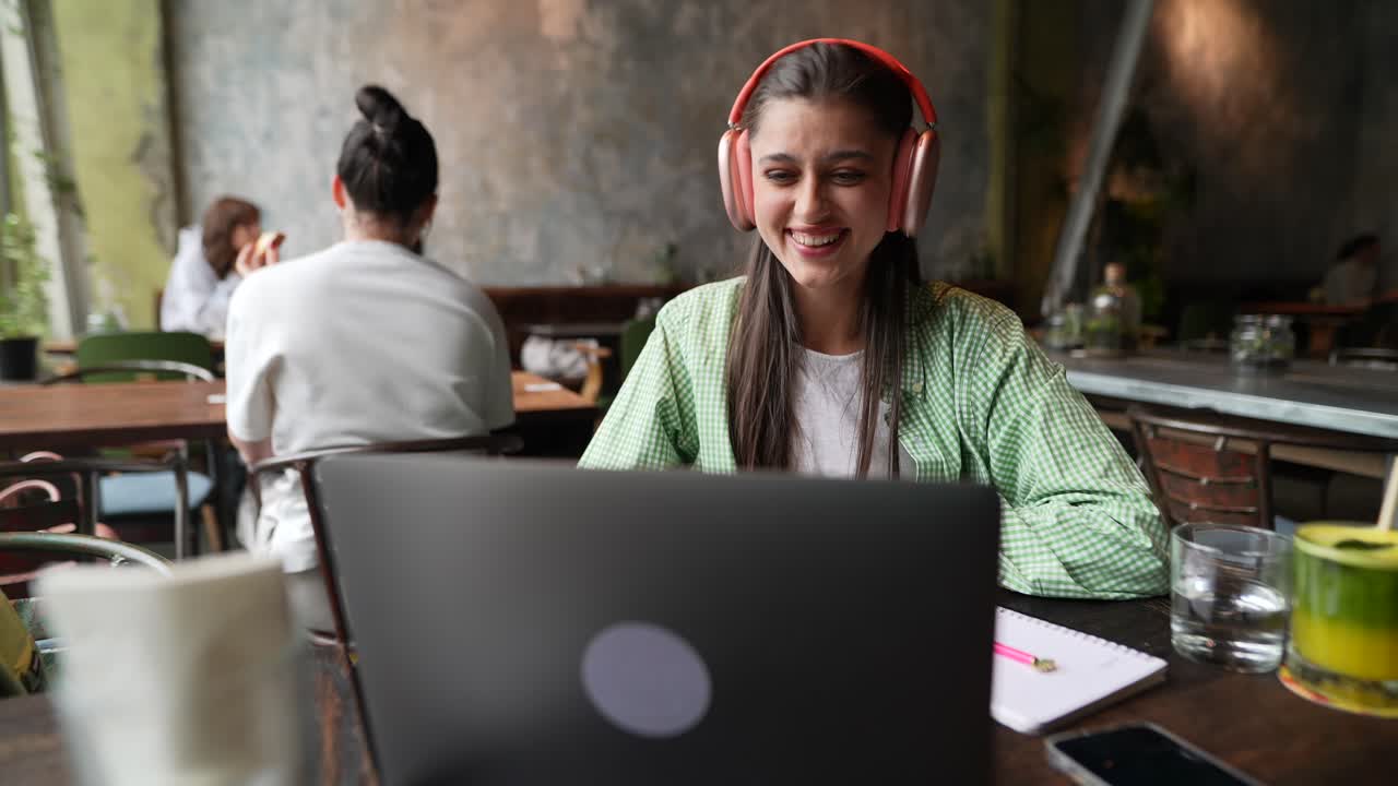 mujer trabajando en una computadora portátil en un café