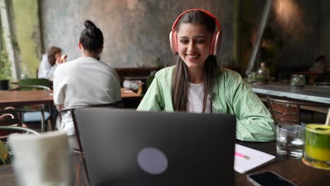 mujer trabajando en una computadora portátil en un café