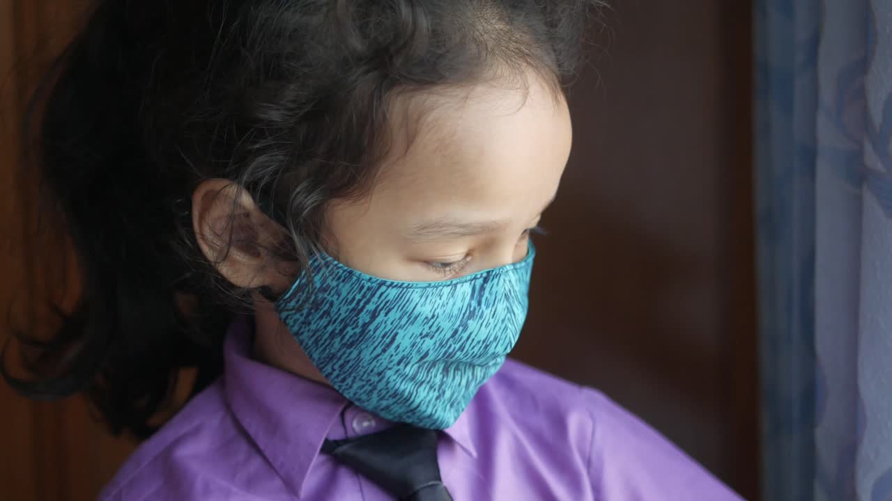 niño con máscara en la ventana