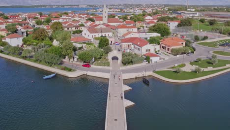 Old-stone-bridge-connecting-Nin-to-mainland-Croatia,-sunny-day,-aerial