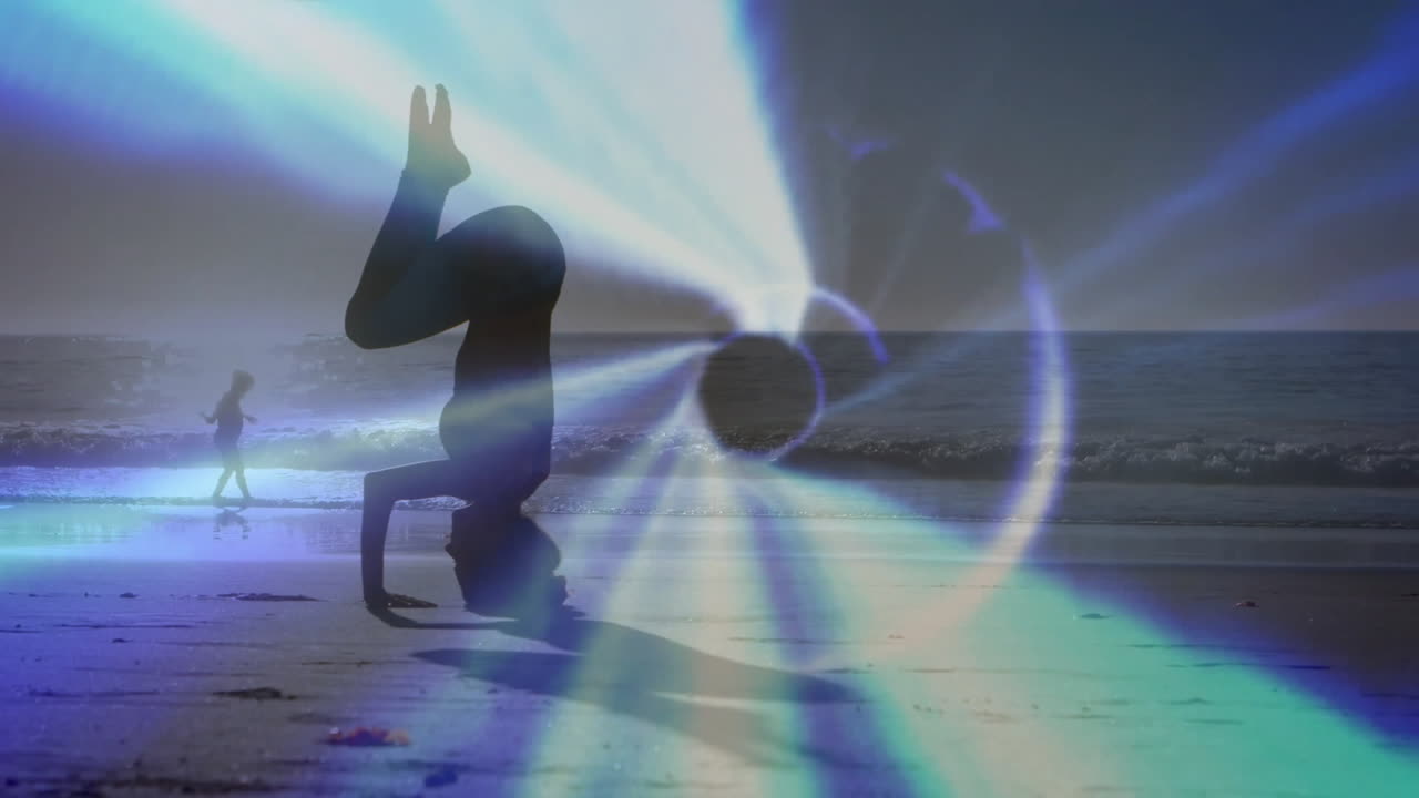 Woman performing headstand on sandy beach at sunrise, with animated light ring suggesting health