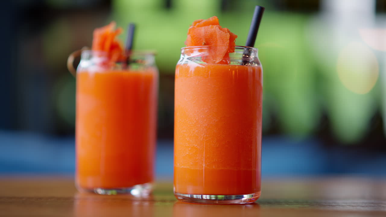 Two glasses of carrot juice, on the table at a restaurant