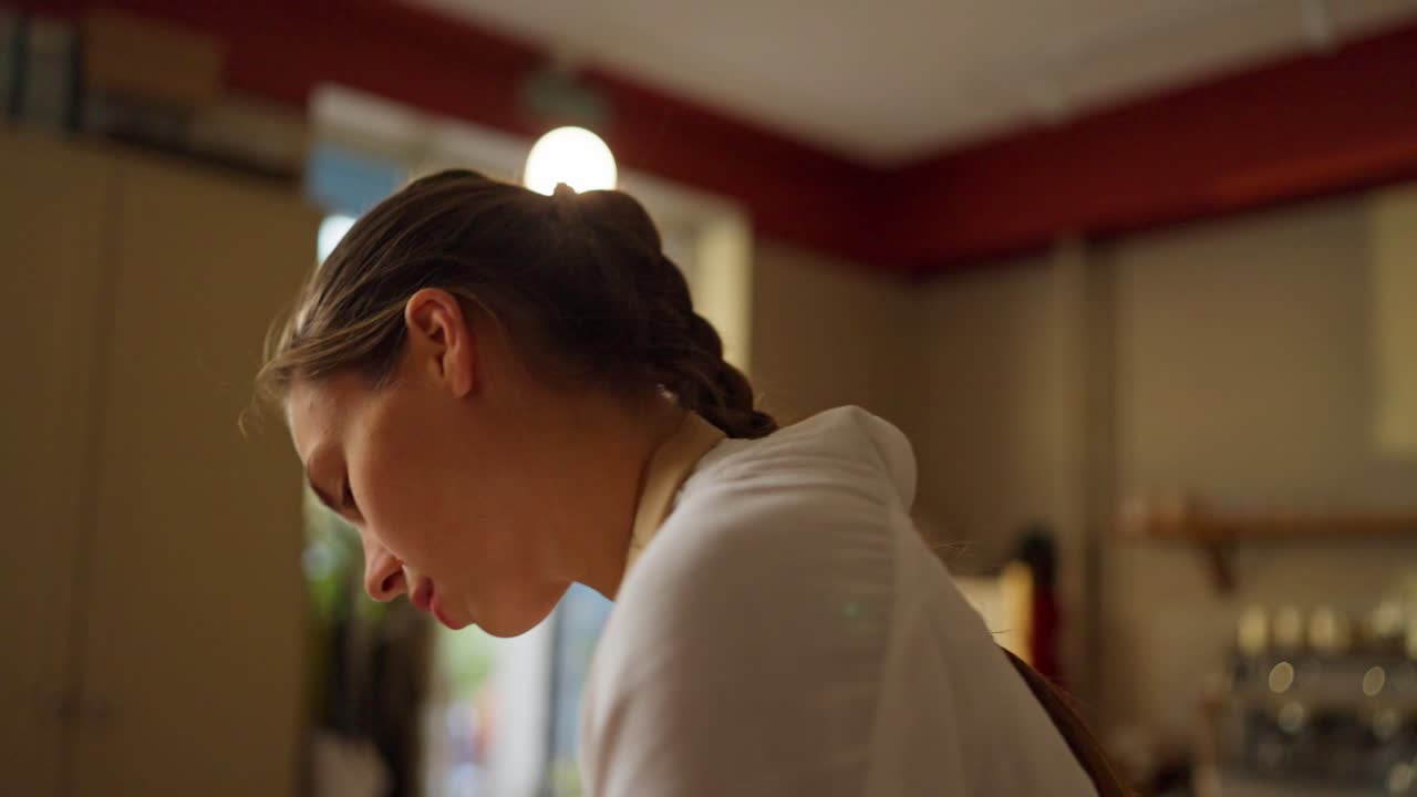 彼女のキッチンでパンを焼く若い女性