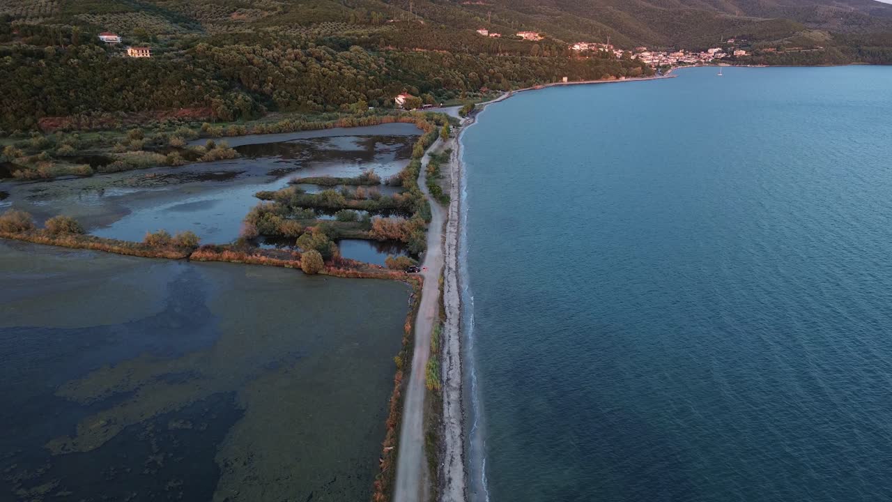 puente de tierra que conduce a través del agua hacia el continente