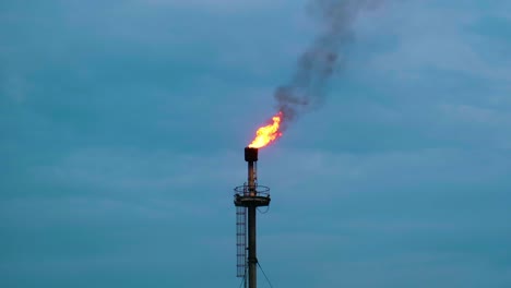 Ölraffinerie-Feuer-Gasfackel-Gegen-Bewölkten-Himmel---Low-Angle-Shot