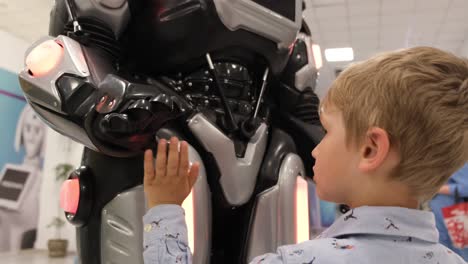children look at a humanoid robot at the exhibition children look at a humanoid robot at the exhibition smart robot with artificial intelligence exhibition of modern technologies ukraine kiev may 22 2021