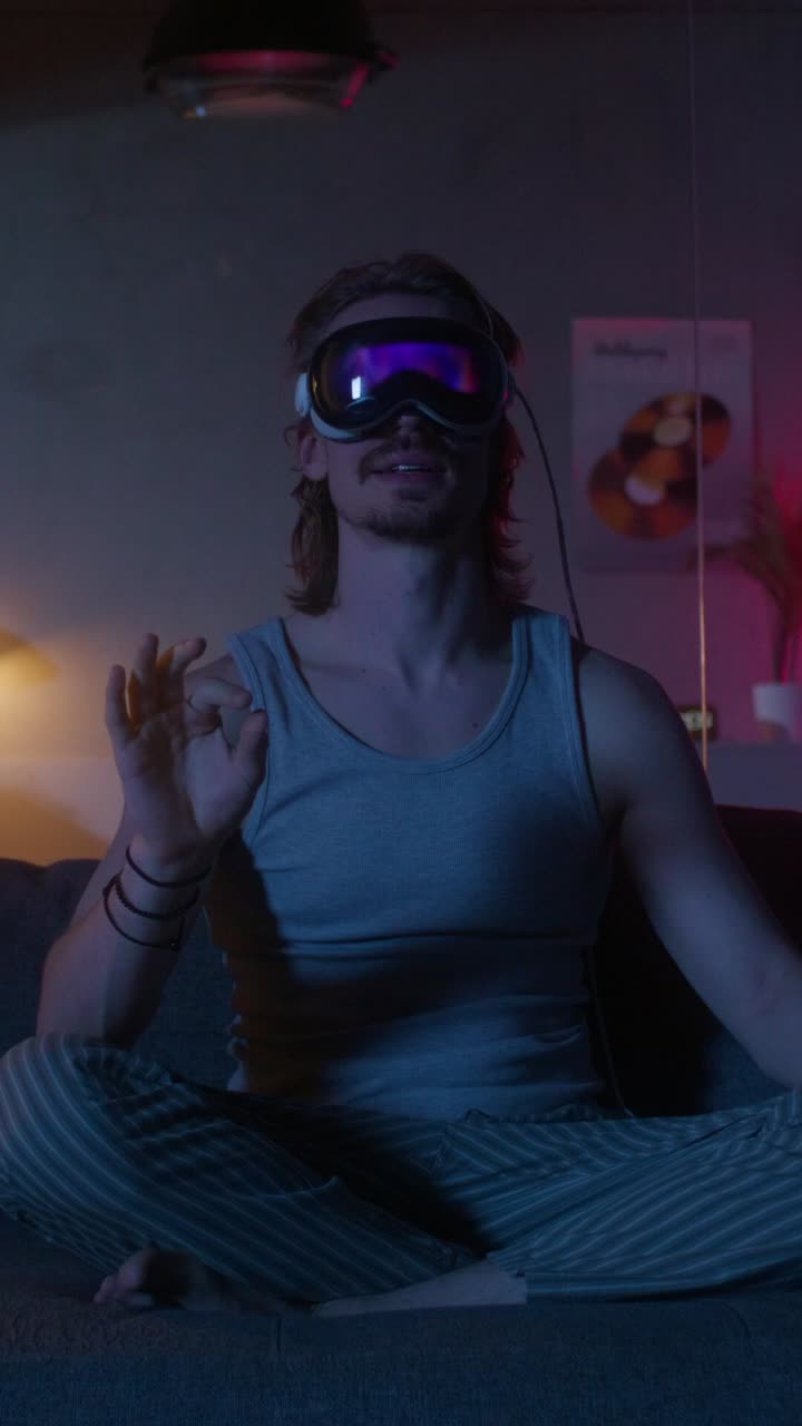 Uomo che usa un visore VR sul divano a casa