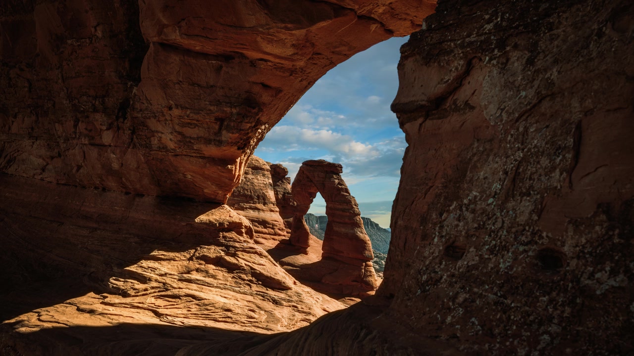 Rekaman selang waktu awan bergerak di atas formasi batuan pasir ikonik Delicate Arch di Taman Nasional Arches, AS