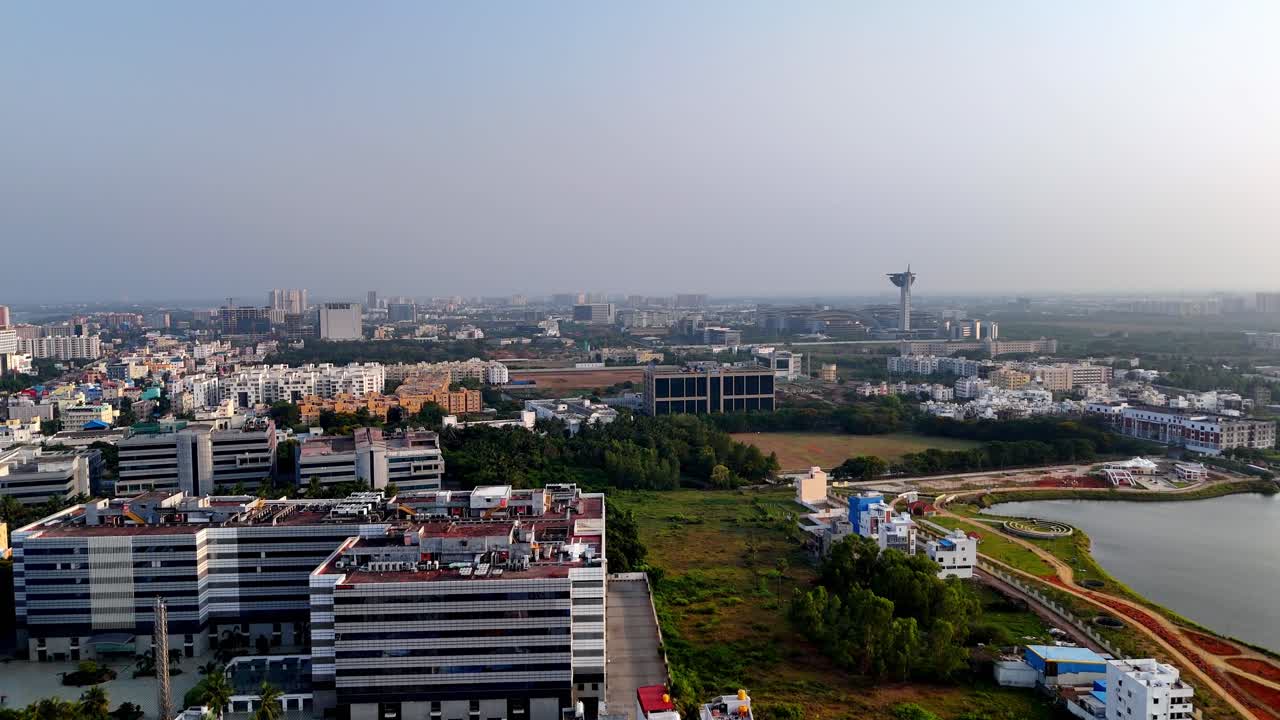 High-angle aerial view of a sprawling urban landscape, likely an IT or technology hub. The scene features a mix of modern low-rise commercial buildings and mid-rise residential structures
