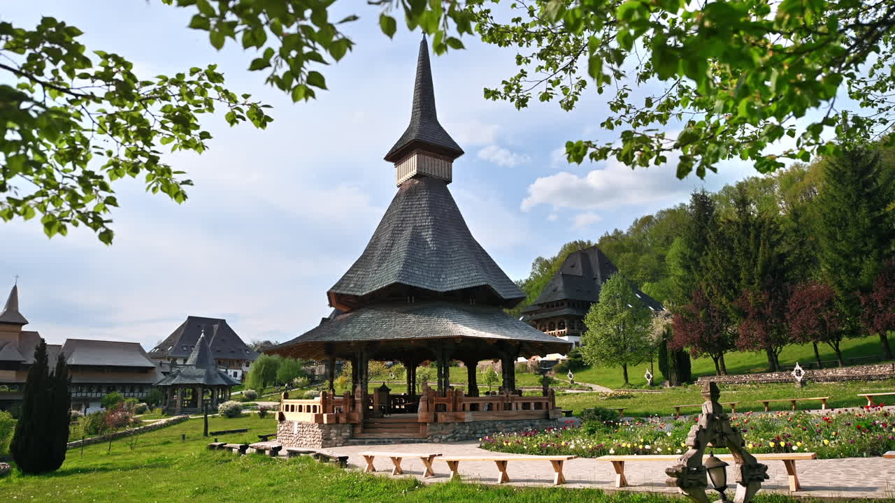 View of the Barsana Monastery, Romania. Inner court with gazebo and others buildings, greenery, forest around it