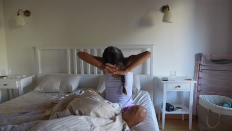 mujer estirándose en la cama por la mañana