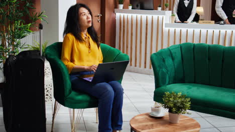 Hotel-guest-working-on-laptop-in-lounge-area-lobby