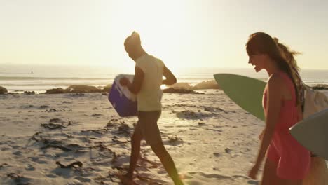 young adult friends walking on a beach at sunset 4k