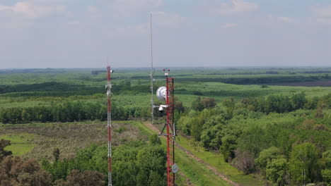 bird’s-eye view of a communication tower nestled among vibrant green trees. this shot showcases the contrast between the tower’s structure and the natural surroundings, offering a peaceful perspective