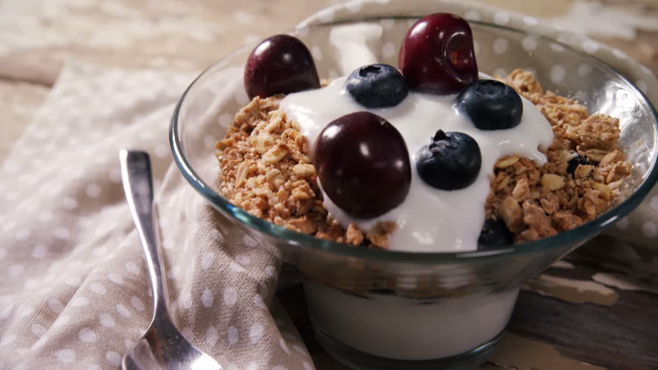 tazón de muesli de yogur, cerezas y arándanos para el desayuno 4k
