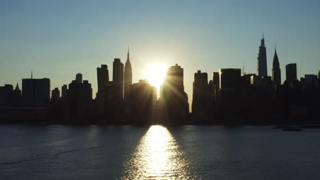 Heller-Blick-Nach-Oben-Auf-Den-East-River-Mit-Blick-Auf-Das-Seltene-Manhattanhenge-Phänomen-Und-Seinen-Intensiven-Sonnenstrahl-Durch-Die-Gebäude