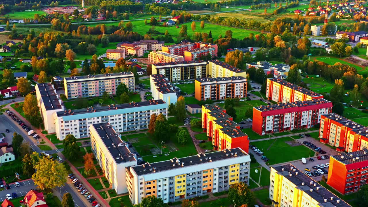 Dzielnica apartamentów w Valmierze o zachodzie słońca z kolorowymi blokami i terenami zielonymi