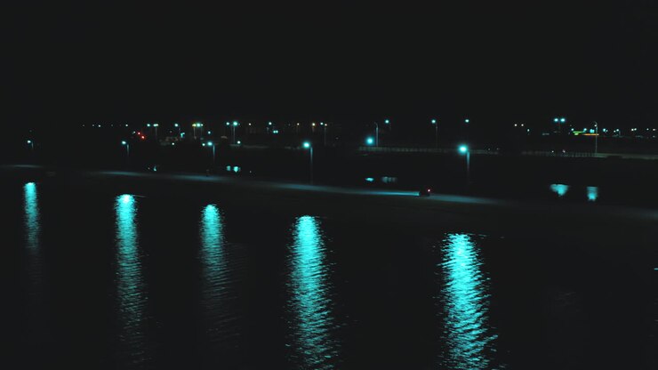 Flight from a height behind a rushing sports motorcycle along the river against the backdrop of the