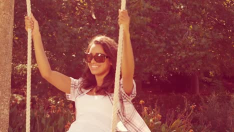 pretty brunette doing swing in park