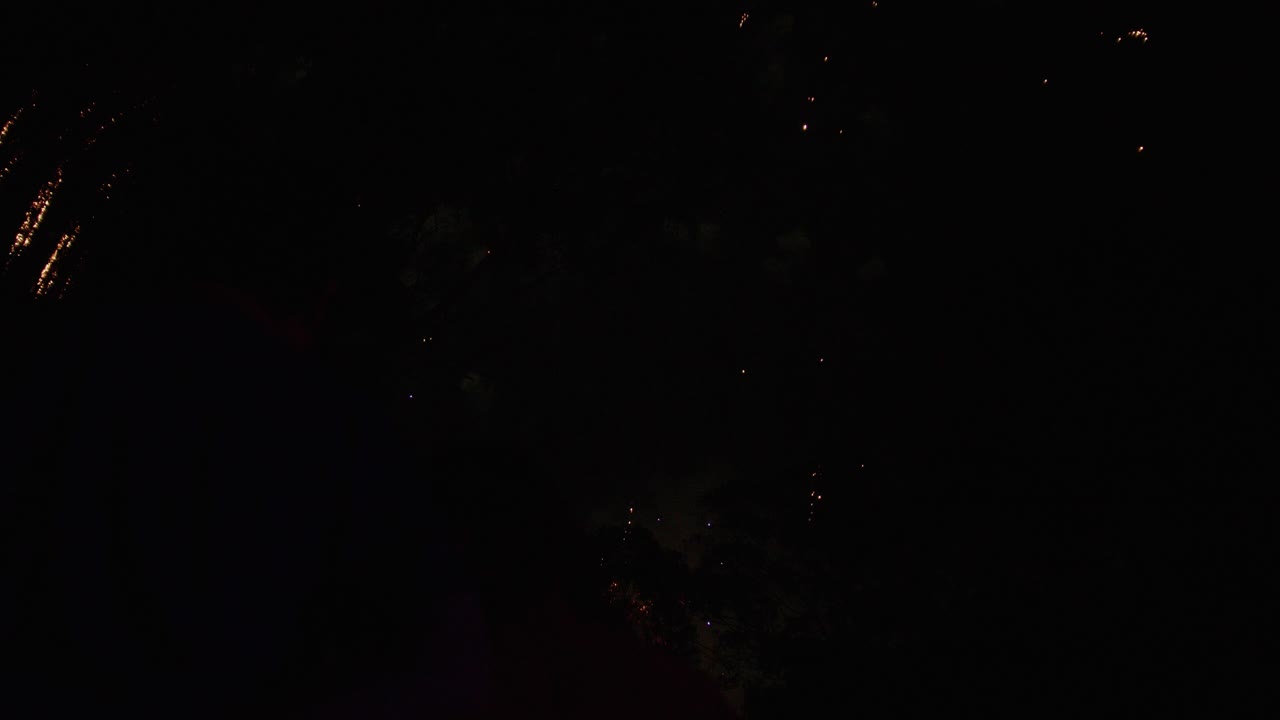 Father and child enjoy a massive fireworks display that takes over the sky