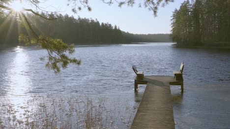 vacant wooden benches on end of wooden pier beside picturesque lake niedrajs