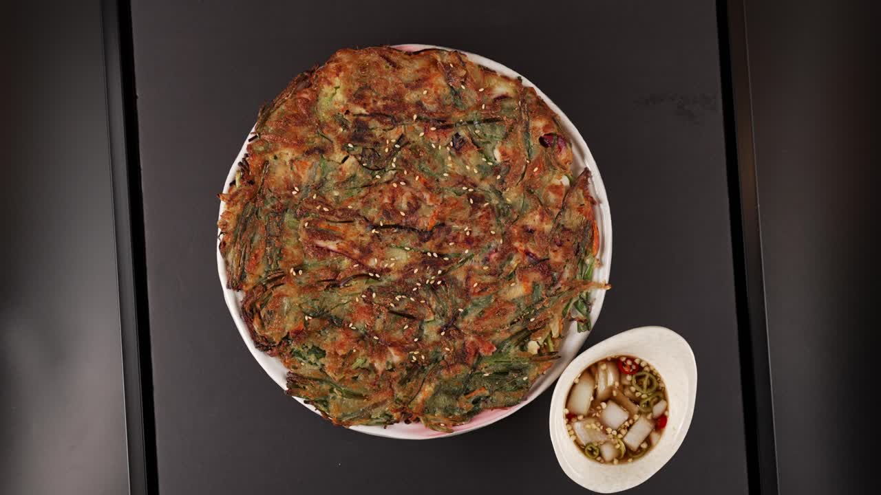 A crispy seafood and chive pancake with a chewy bite, perfect with soy sauce. 바삭하고 쫄깃한 해물 부추전, 간장 소스와 잘 어울리는 한 접시.