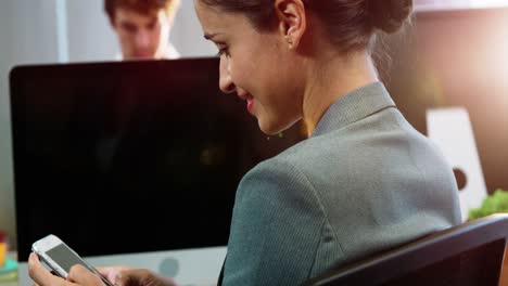 mujer de negocios usando un teléfono móvil en la oficina