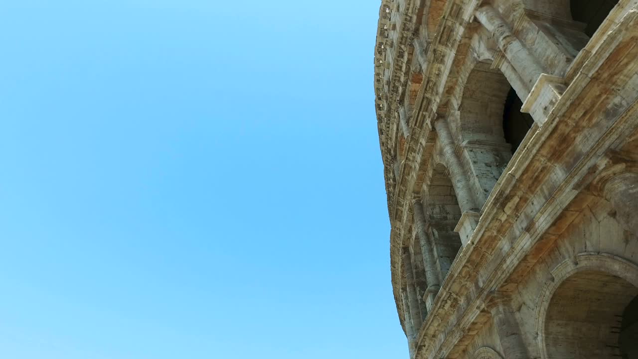 Ruins of the colosseum in Rome, Italy against blue sky