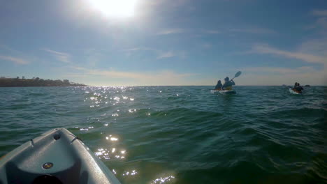 a group of kayakers rowing towards the sun in the middle of the sea at san diego