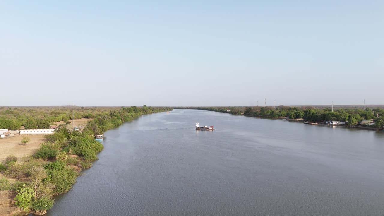 Panoramic view of the Gambia River with green banks and clear skies, a typical scenic African river landscape
