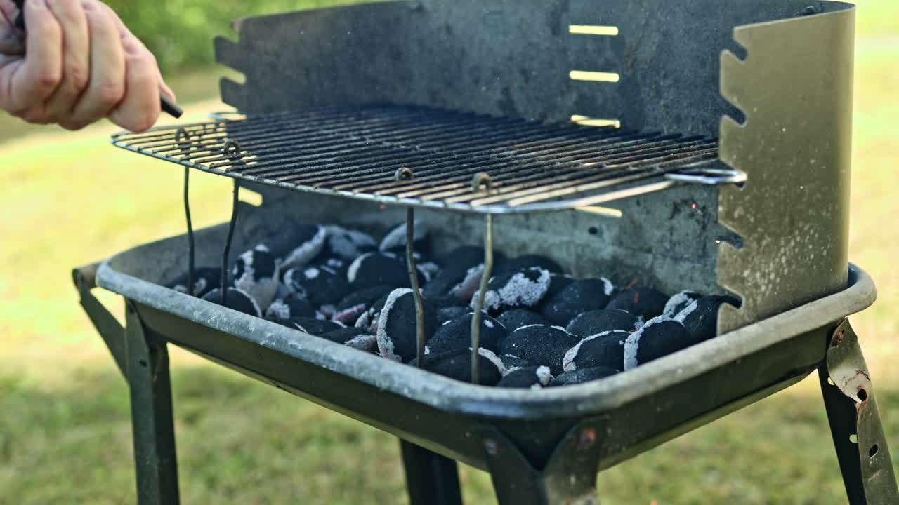 炭火バーベキュー用の屋外グリル。肉を焼くためのグリル内の熱い炭。グリル内の炭から立ち上る煙。屋外グリル用の木炭ブリケット。
