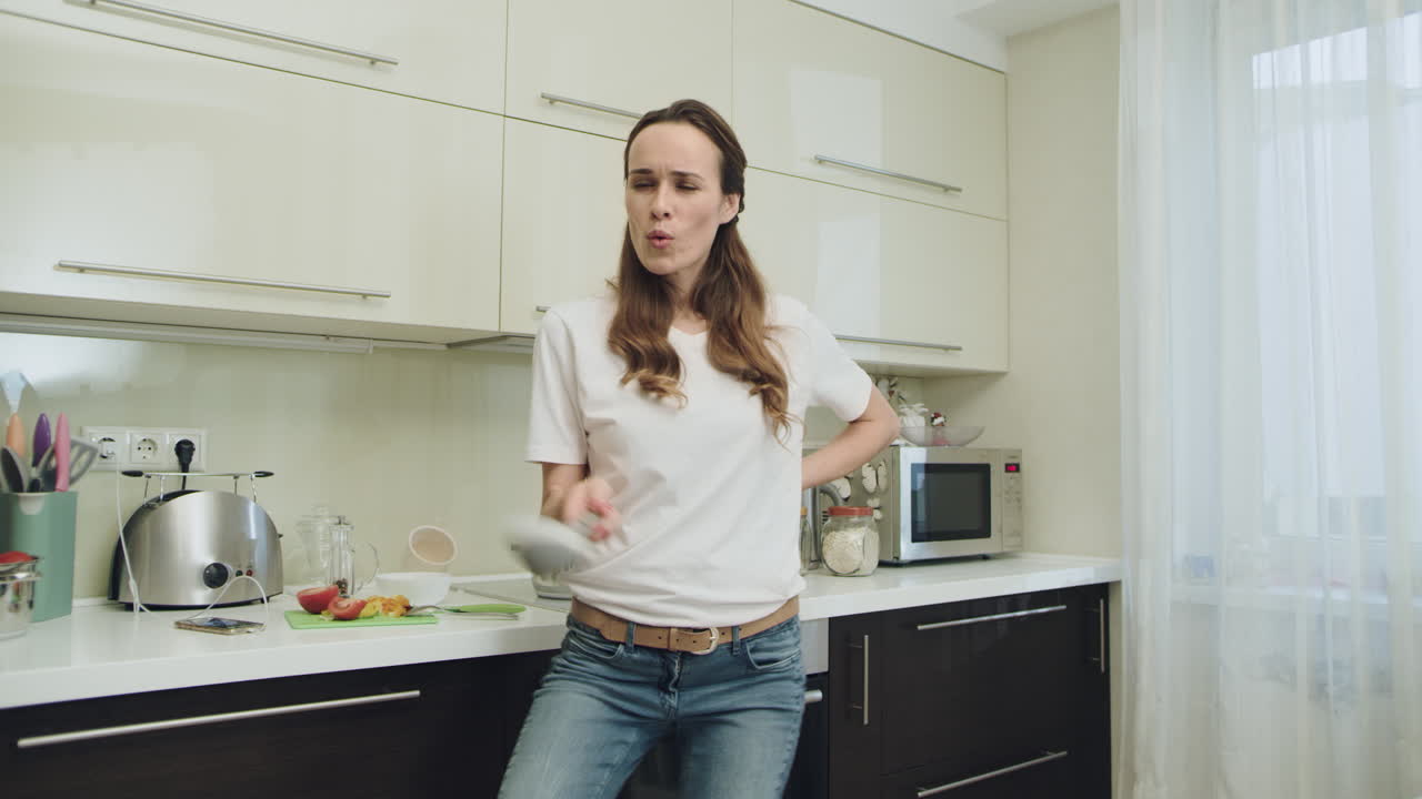 Donna felice che si diverte in una cucina moderna. Ragazza sorridente che prepara una gustosa zuppa.