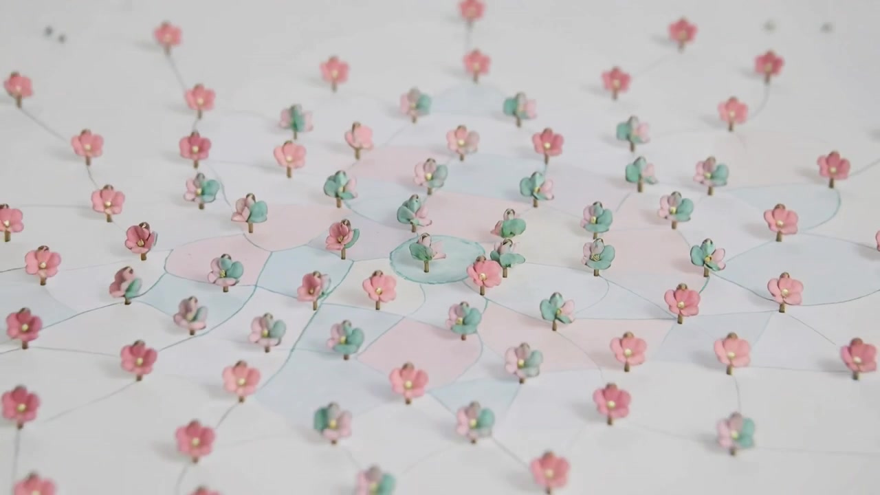 Frame changing, camera moving, revealing tiny flower pins with threads and gold beads