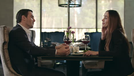 Love-couple-sitting-at-restaurant.-Man-touching-woman-hand-at-dinner