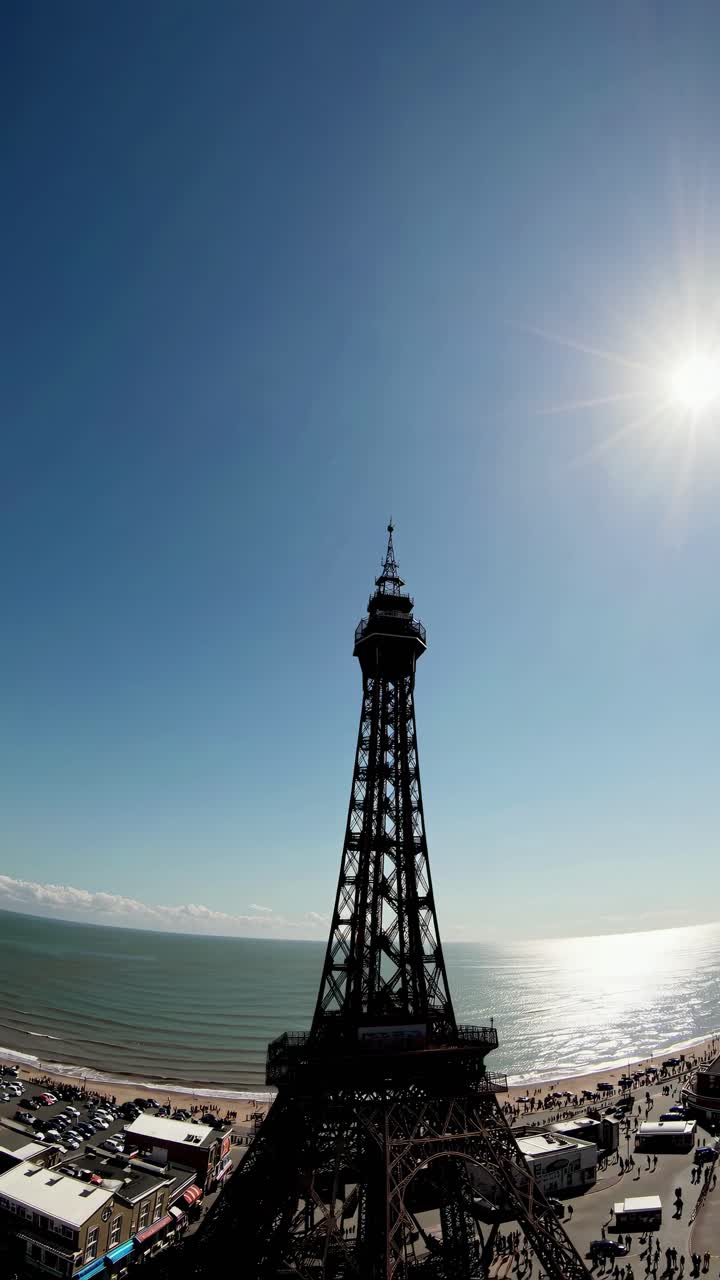 Aerial video angle of a coastal tower against a sunny sky, capturing the vibrant seaside atmosphere