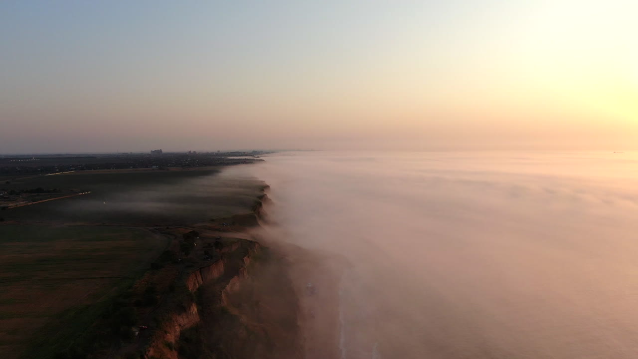 un amanecer brumoso en la orilla del mar