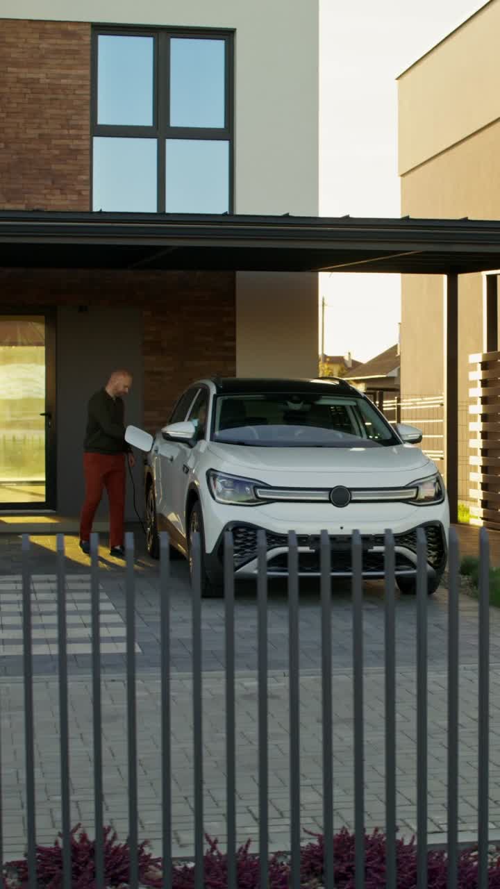 집에서 전기 차량을 충전하는 남자