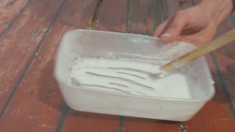 mixing cascamite wood glue in tupperware container for wooden roof plank repair