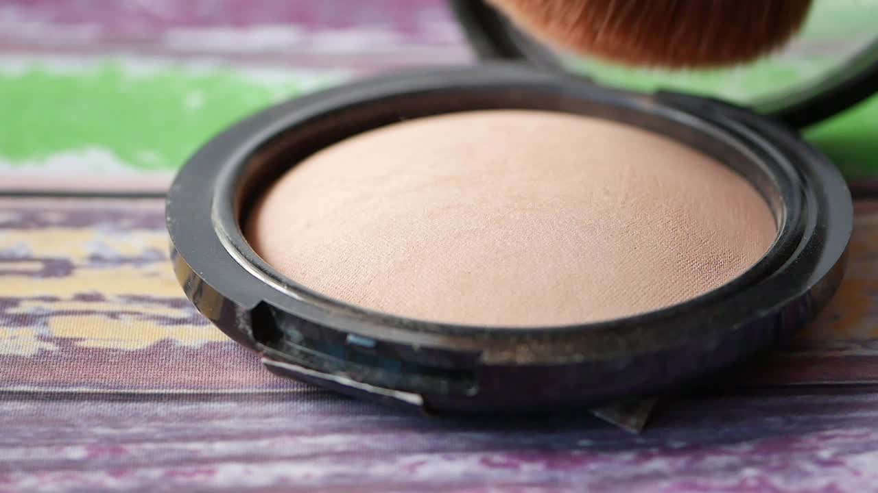 la aplicación de polvo de maquillaje con un pincel