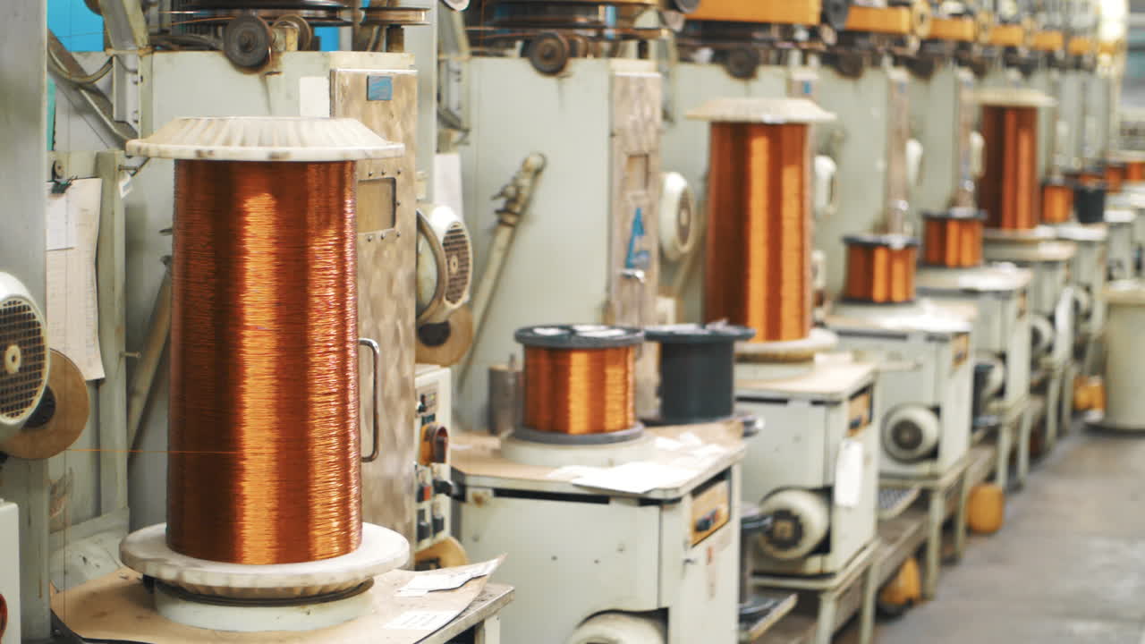 Copper wire winding on coils at factory. Bronze cable rolling on reels at plant