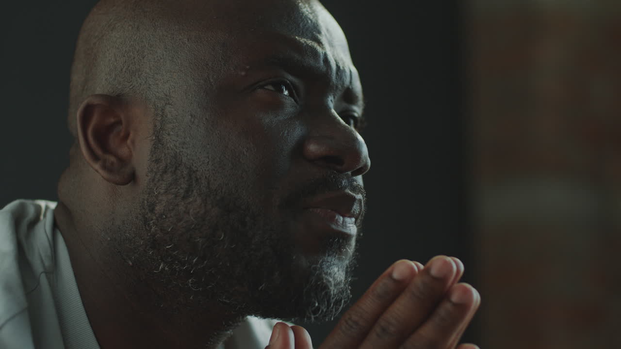 Black Man Holding Palms Together and Whispering a Prayer