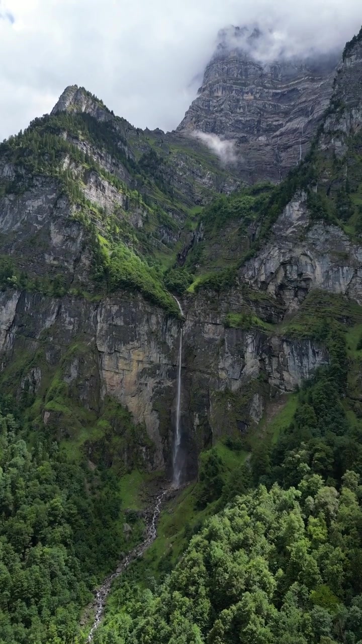 Cascata Tscholbodenfall sulla sponda meridionale del Lago Klöntal, Glarona, Svizzera, video verticale.