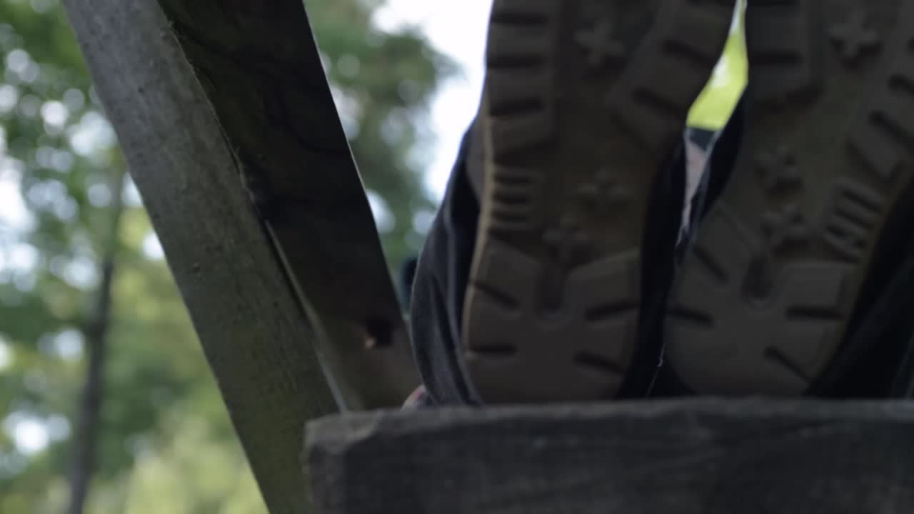 Feet resting on a park bench looking at a mobile phone