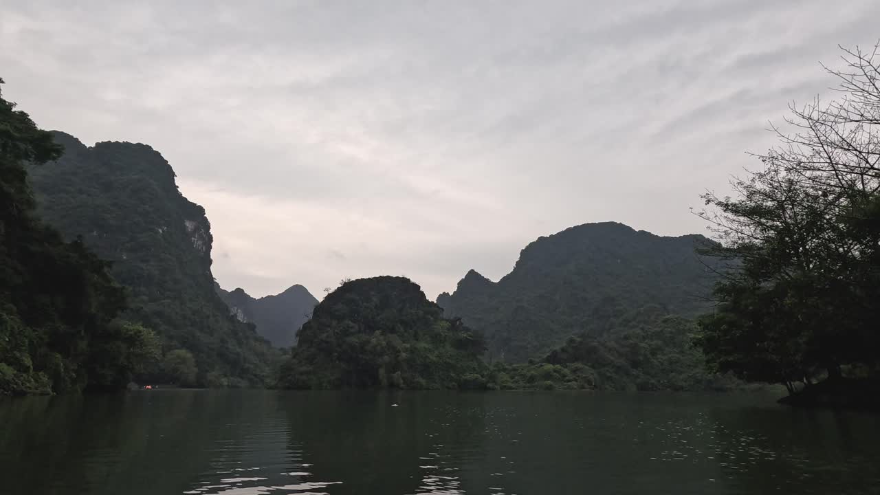 Boats navigating a tranquil river amidst lush mountains