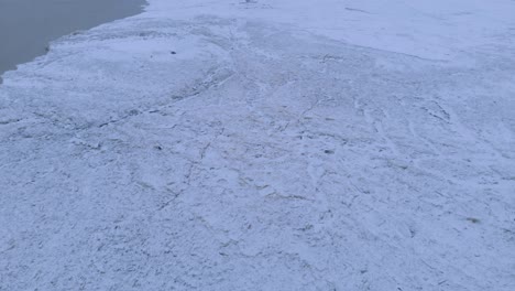 Toma-Real-Alejándose-De-Una-Presa-De-Hielo-En-Un-Río-De-Invierno