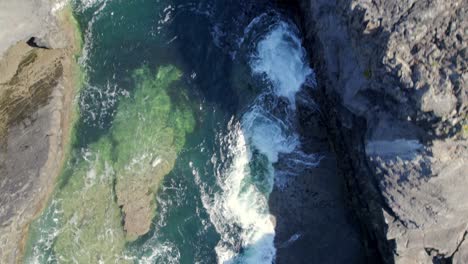 Flyby-over-rocky-coast-while-facing-down