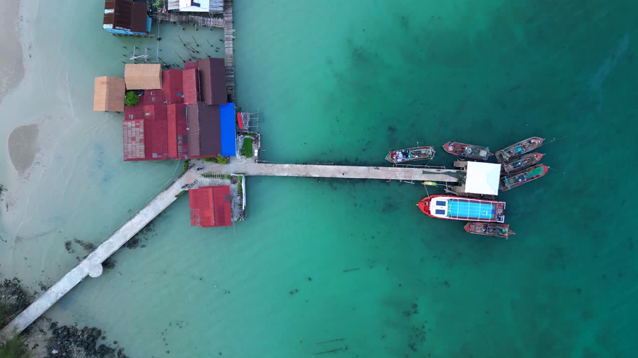 cambodia Koh Rong island, capturing the essence of tropical paradise with its lush palm trees, vibrant turquoise waters, and traditional stilt houses. Stunning aerial view flight ascending drone